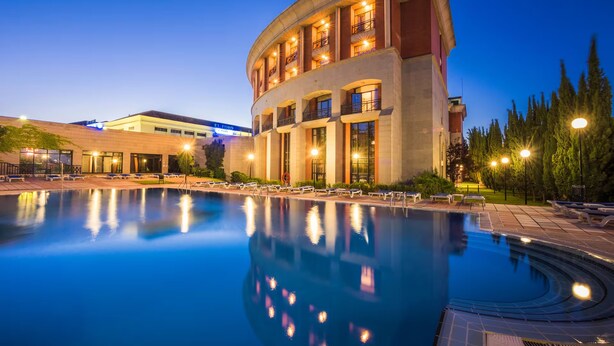 A hotel with a pool, a curved building, and a sign reading "EL FAMNO". - AZZ Mérida Medea (Merida)