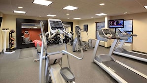 A gym with treadmills, elliptical machines, and free weights.