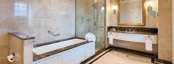 A modern bathroom with a glass-enclosed shower, a freestanding bathtub, and a vanity with a marble countertop.