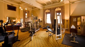 Ett välutrustat gym med olika träningsmaskiner, ett löpband och en träningsbänk.