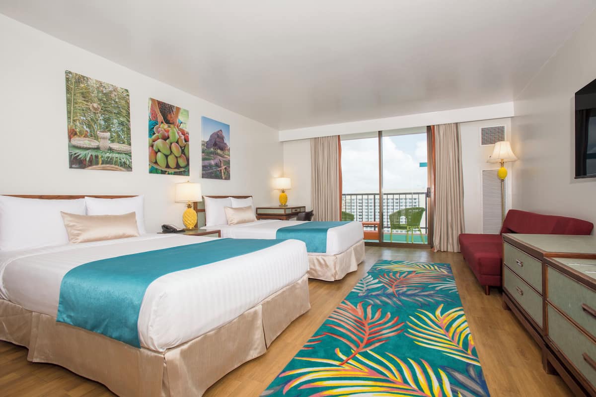 A hotel room with two beds, a balcony, and a view of the city.