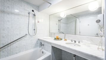 Een moderne badkamer met een badkuip, douche, wastafelmeubel en een grote spiegel.