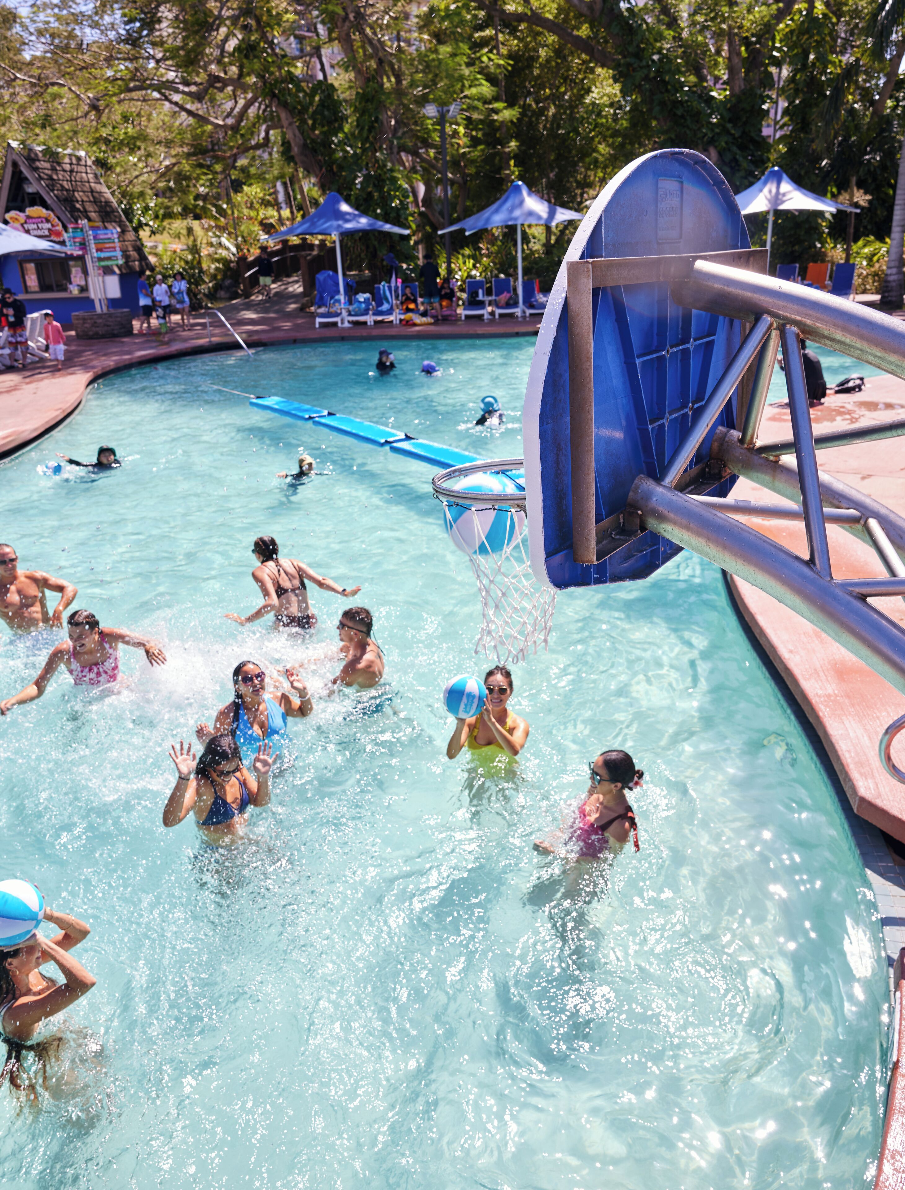 A swimming pool with a water slide and lounge chairs.