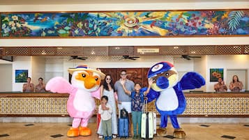 A reception area with a large mural, a 'Room Check In' sign, and a reception desk with staff.