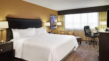 Senger med overmadrass, safe på rommet, skrivebord og blendingsgardiner