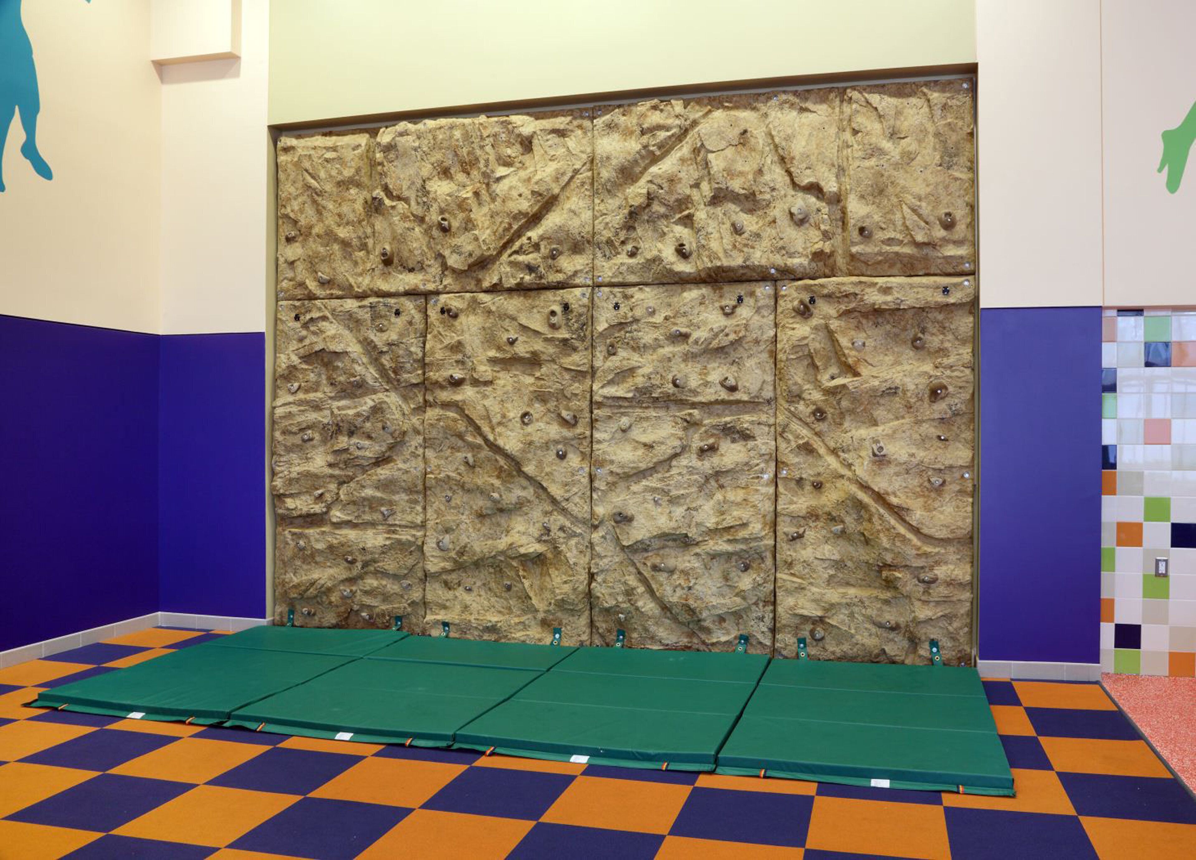 Una pared de escalada con suelo a cuadros y superficie texturizada.