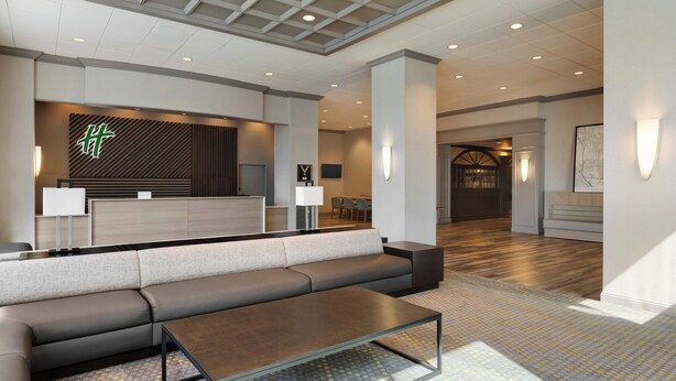 A modern lobby with a sofa, a coffee table, and a reception desk.