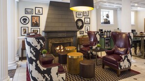 A well-appointed lounge area with a fireplace, leather armchairs, and a checkered floor. - The Willows Hotel (Chicago)