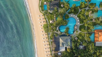 On the beach, white sand, beach cabanas, sun loungers