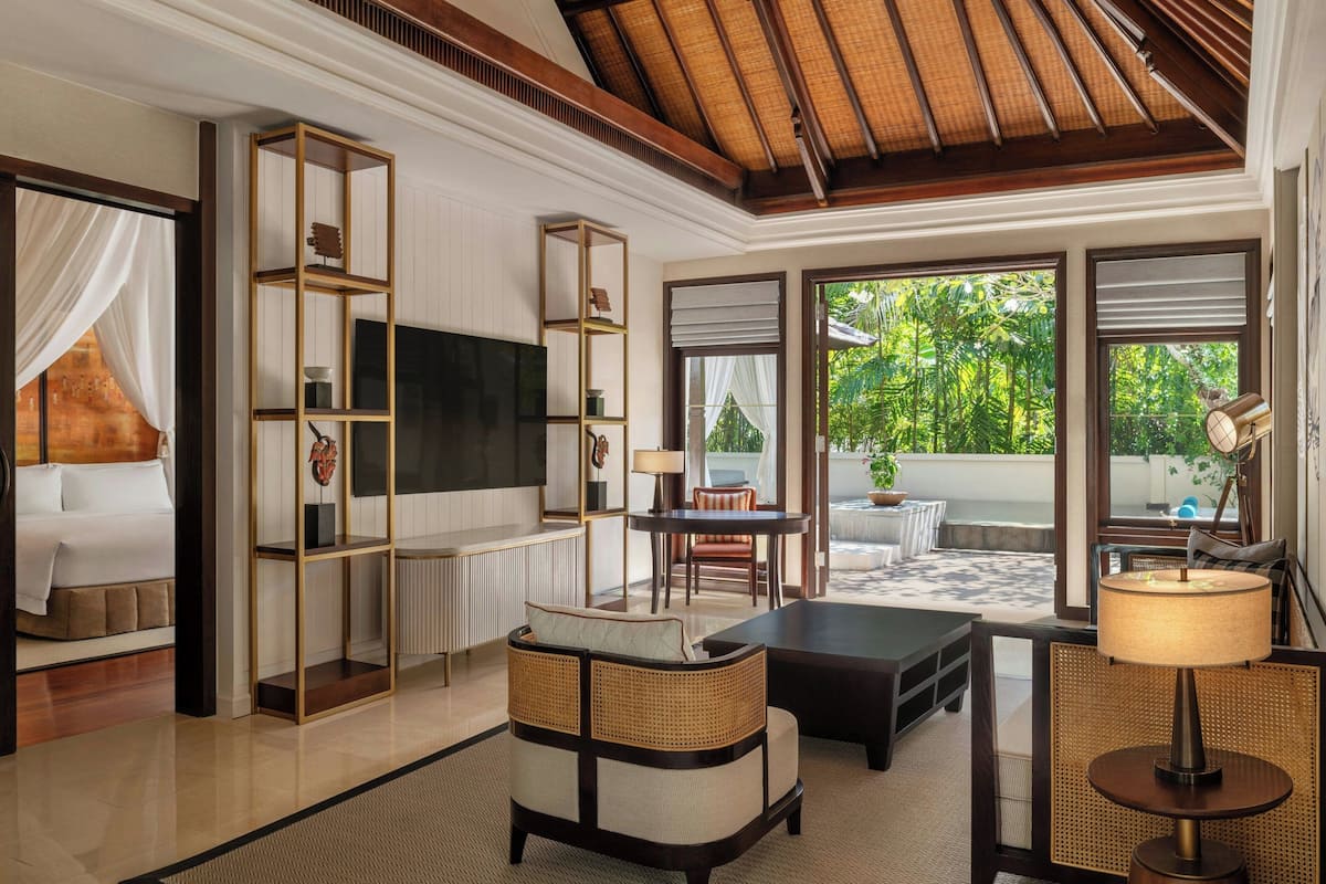 A modern living room with a flat-screen TV, a sofa, a coffee table, and a dining area with a table and chairs.
