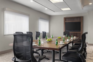 A conference room with a long table, chairs, and a large screen. - Holiday Inn & Suites Overland Park West by IHG (Lenexa)