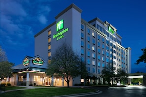 A Holiday Inn hotel with a modern design, featuring a prominent green logo and signage for the Holiday Inn & Suites. - Holiday Inn & Suites Overland Park West by IHG (Lenexa)