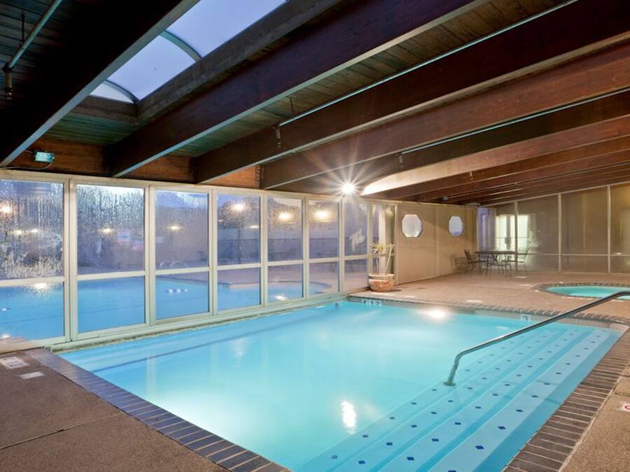 Een binnenzwembad, een buitenzwembad en ligstoelen