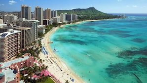 A coastal cityscape with high-rise buildings, a beach, and clear turquoise waters. - Sheraton Waikiki Beach Resort (Honolulu)