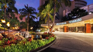 Sheraton Waikiki hotel entrance with a landscaped garden, palm trees, and a water feature. - Sheraton Waikiki Beach Resort (Honolulu)