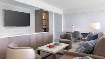 A modern living room with a flat-screen TV, a sofa, a coffee table, and a lamp.