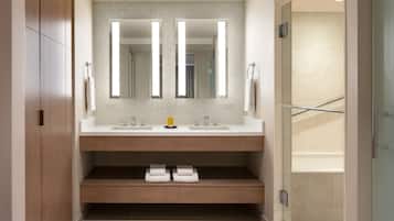 Un baño moderno con dos lavamanos, un espejo grande y una zona de ducha.