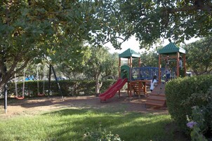 A playground with swings, a slide, and a climbing structure.