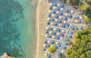 Aan een privéstrand, wit zand, gratis strandhuisjes, ligstoelen