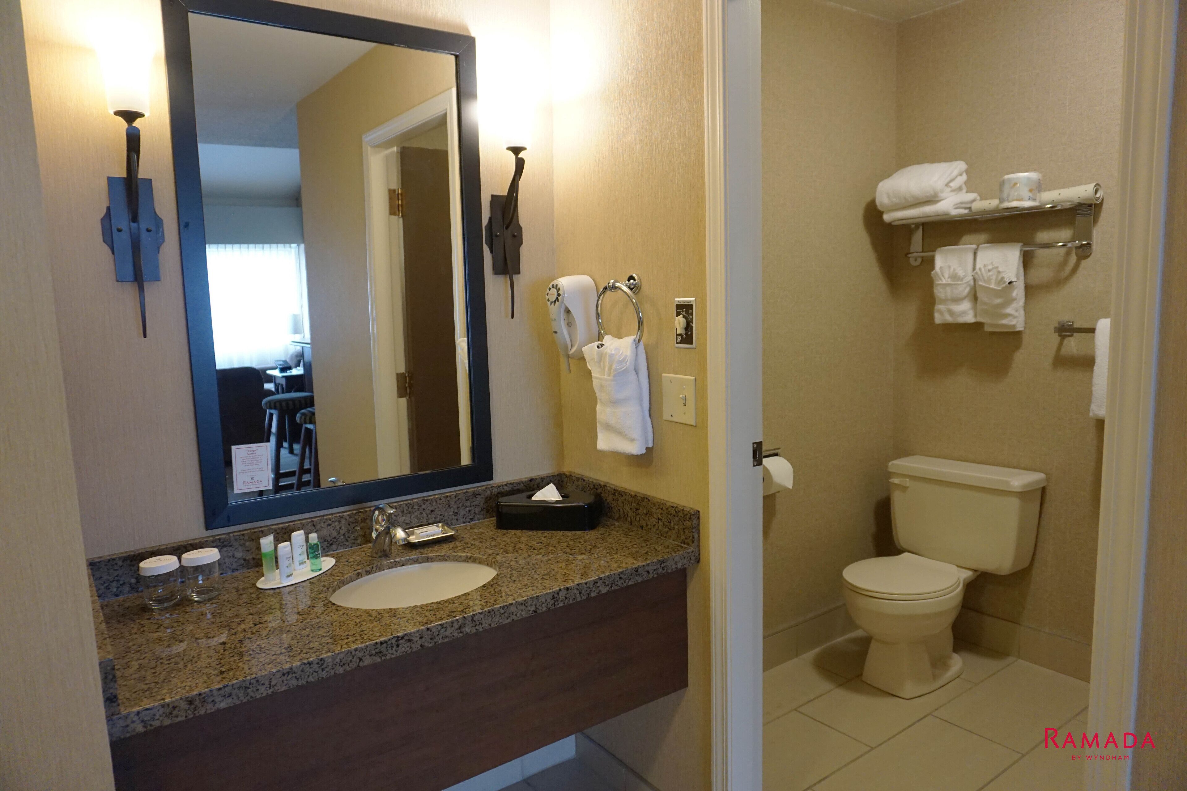 Une salle de bain équipée d’un lavabo, d’un miroir, d’un porte-serviettes et de toilettes.