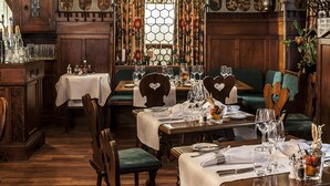 Une auberge traditionnelle, avec un mobilier en bois, une porte d’entrée centrale en arc de cercle et une salle à manger aménagée pour accueillir les clients.
