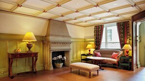 Une pièce avec une cheminée, un canapé, une table et une lampe.