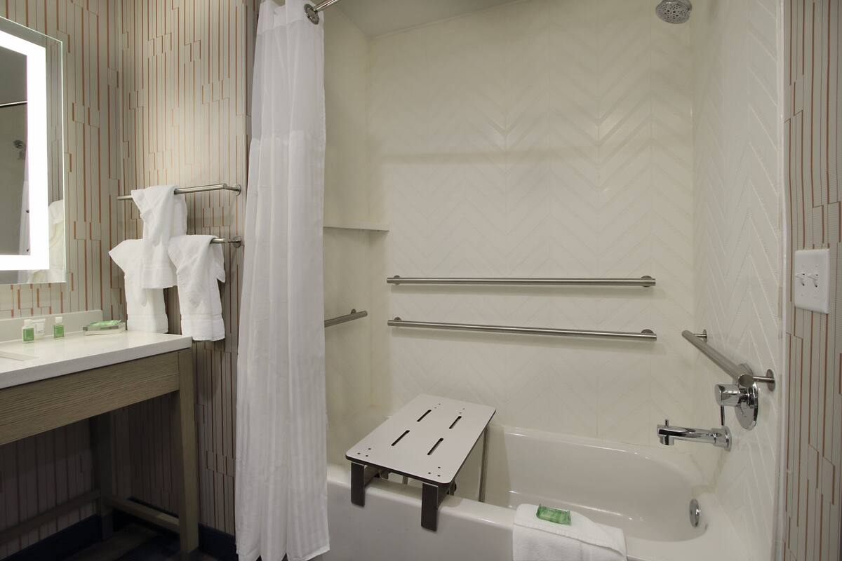 Un baño moderno con ducha, bañera y tocador con espejo.