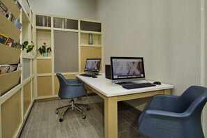 Een modern kantoor met twee bureaus, twee stoelen, een boekenkast en een vaas.