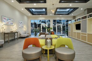 Un espace de restauration moderne doté d’un haut plafond, de lucarnes et de grandes fenêtres offrant une vue sur l’extérieur.