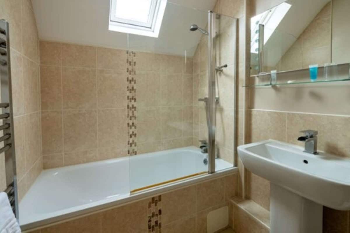 Une salle de bain avec une baignoire, un lavabo et une douche.