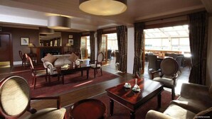 A spacious hotel lobby with a fireplace, comfortable seating, and large windows. - Buchanan Arms Hotel & Leisure, Sure Hotel Collection (Drymen)