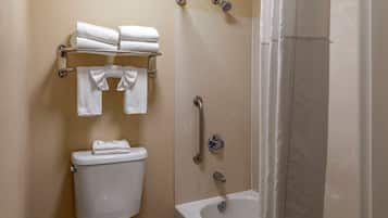 A bathroom with a toilet, a towel rack with folded towels, a shower with a grab bar, and a bathtub.
