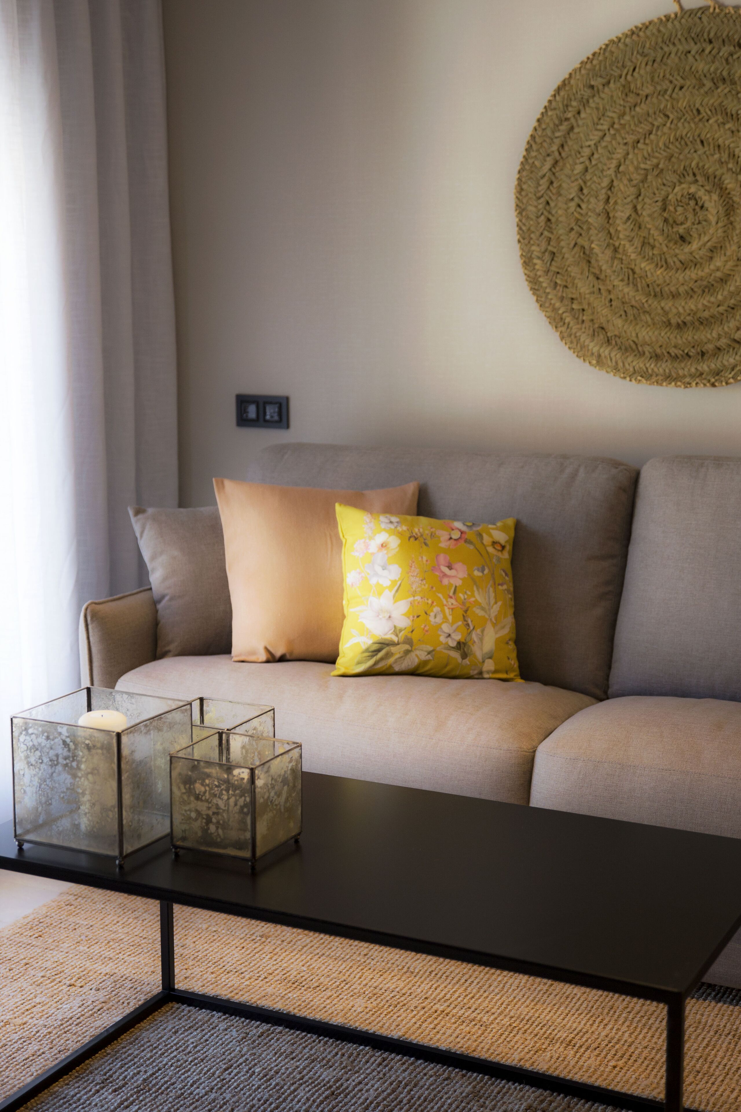 Una sala de estar con sofá, una mesa de centro y un tapiz decorativo.