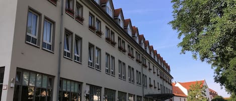 Un edificio de varios pisos con grandes ventanales y un espacio al aire libre techado.