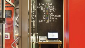 A modern workspace with a computer, printer, and a wall displaying business-related words. - ibis Erfurt Altstadt (Erfurt)