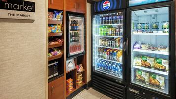 A vending machine area with a Pepsi refrigerator, a microwave, and a freezer stocked with snacks and beverages.