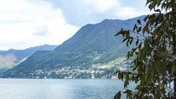 A lake with a mountain in the background and a railing in the foreground.