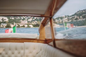 A boat interior with a view of a coastal town and flags.