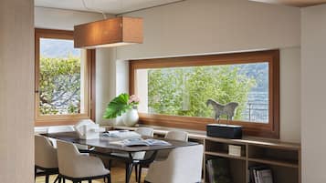 Een moderne eethoek met een houten tafel, stoelen en een boekenkast.