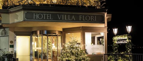 Hotel Villa Floris con entrada de vidrio, un árbol de Navidad y un letrero para RaImoni.