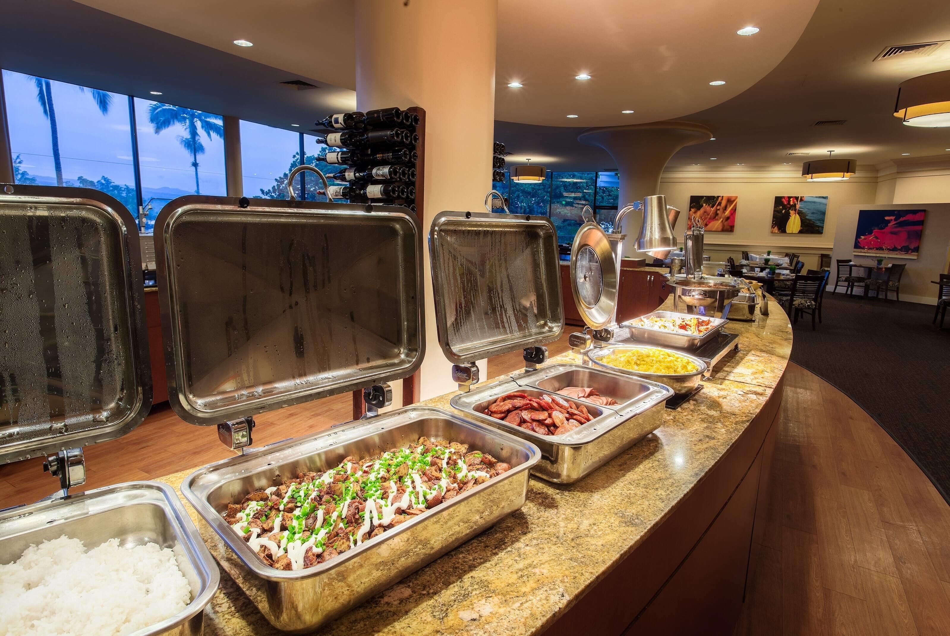 A buffet with various food options, including rice, meat dishes, and sauces.