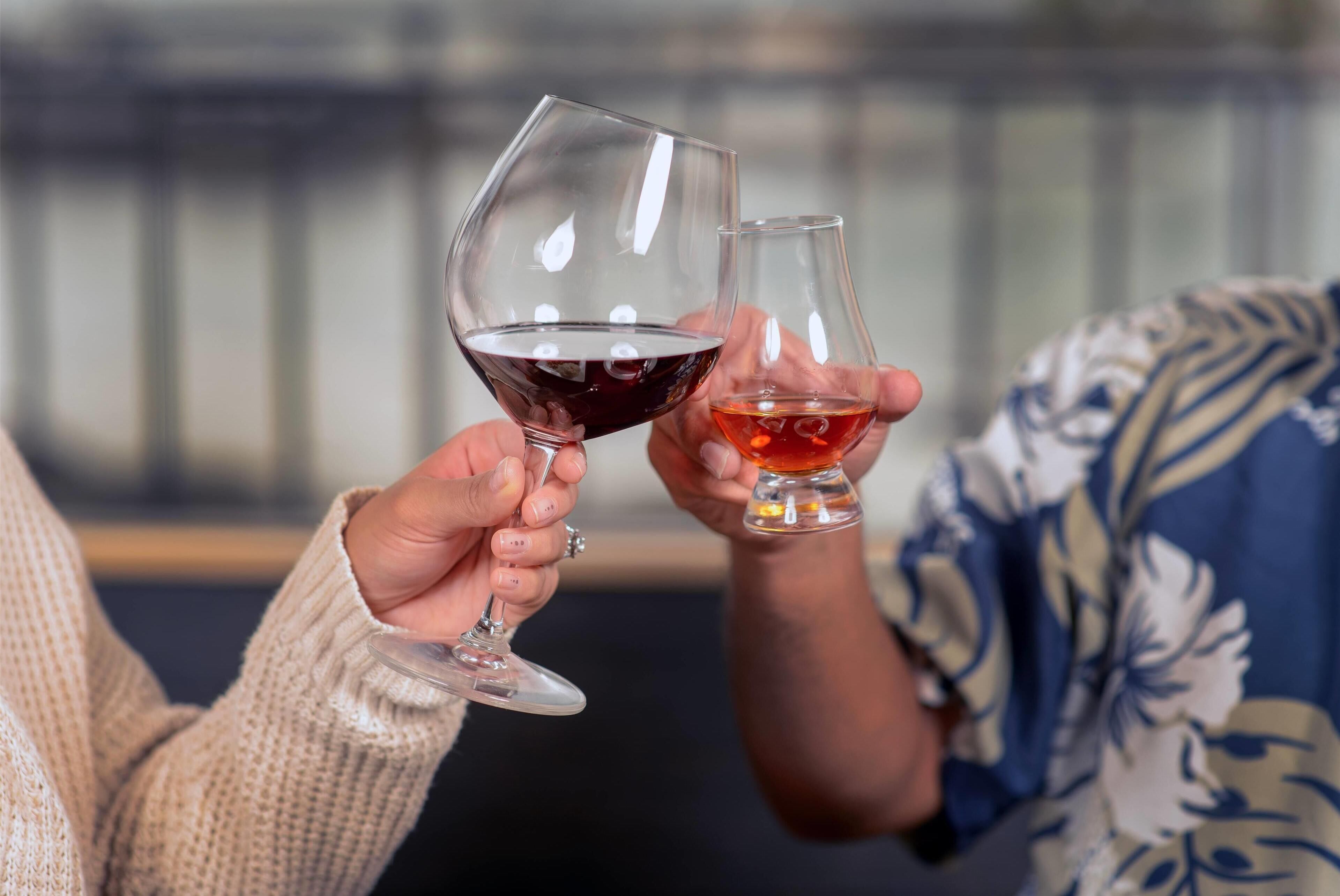 Duas pessoas segurando copos de vinho.