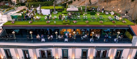 A rooftop terrace with outdoor seating and a view of the city.