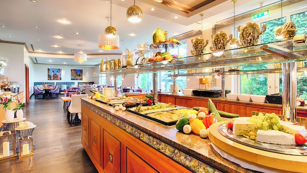 A buffet area with a variety of food items and a seating area with tables and chairs. - Leonardo Hotel Heidelberg (Heidelberg)