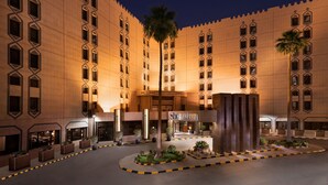 A hotel with a central courtyard, palm trees, and a sign reading "Sheraton." - Sheraton Riyadh Hotel & Towers (Riyadh)