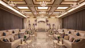 A spacious room with multiple sofas arranged in a semi-circle, a central table, and decorative vases. - Sheraton Riyadh Hotel & Towers (Riyadh)