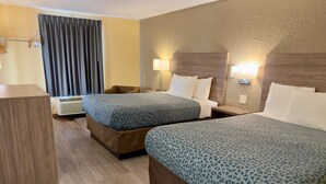A hotel room with two beds, a desk, a chair, and a window with curtains. - Econo Lodge Lansing - Leavenworth (Lansing)
