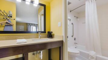 Un baño con lavamanos, espejo y ducha.