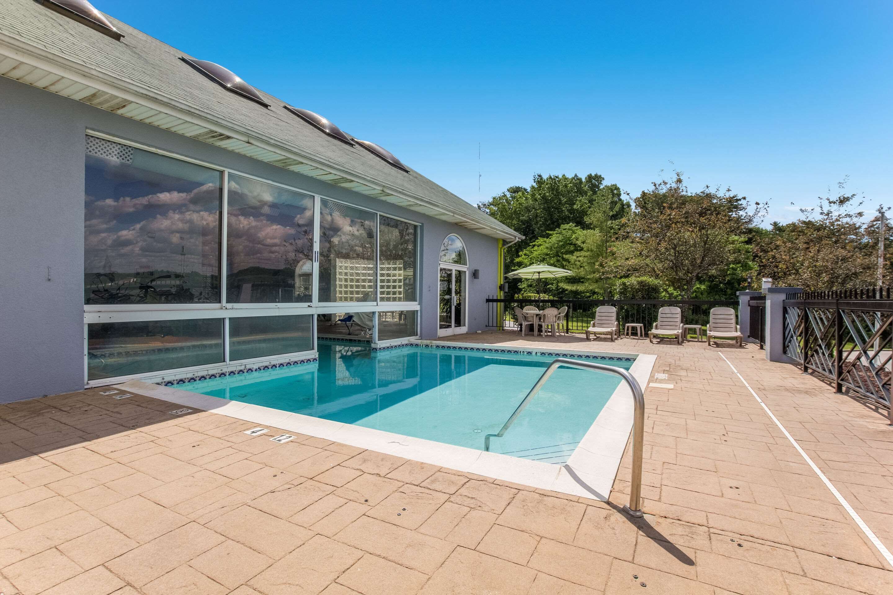 Alberca techada, alberca al aire libre y camastros