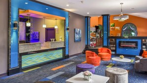 A hotel lobby with a reception desk, seating area, and a fireplace. - Quality Inn London North (London)